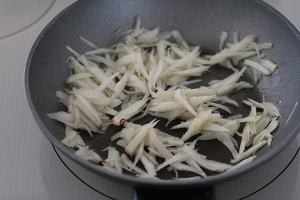 鍋を熱してサラダ油を入れて、水気をきったごぼうと赤唐辛子を炒める。