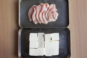 豆腐は横半分に包丁を入れ、3〜4cm幅の正方形にカットする。鶏肉は5mm幅のそぎ切りにし、片栗粉をまぶし、余分な粉をはたき落とす。