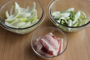豚カルビ肉に塩、粗挽き黒こしょうをふる。玉ねぎは16等分のくし切りにする。長ねぎは6〜8mm幅の斜め切りにする。