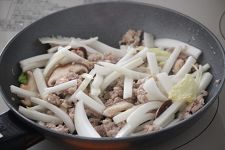 白菜の芯の部分・椎茸を加えてさらに炒め、しんなりしてきたら葉の部分を加えて炒める。