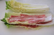 白菜の根元を切り落とす。白菜1枚の上に豚肉1枚をのせて塩少々ふり、これを繰り返して重ねる。