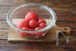 トマトはヘタを取ってお尻の部分に十字の切り込みを入れる。鍋にお湯を沸かしトマトを入れ、皮がめくれてきたら冷水にとり、皮を剥く(湯剥きする)。