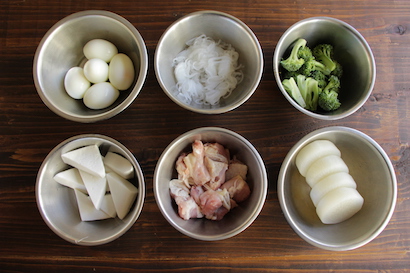 鶏もも肉は皮付きのまま、ぶつ切りにする。大根は2.5cm幅にカットし、皮をむき、面取りする。耐熱皿にひたひたになるくらいの水、大根を入れ、ラップをかけて、600Wの電子レンジで約10分加熱して水にさらす。はんぺんは三角形になるように8等分にカットする。ブロッコリーは小房に分ける。