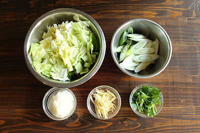 白菜は1cm幅に切り、長ねぎは1cm幅の斜め切りにする。大根は皮をむき、すりおろし、水気を切る。三つ葉は2〜3cm幅に切る。