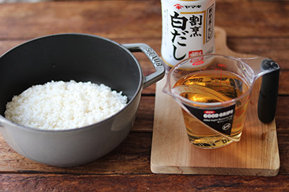 お米をザルにあげて水気をよくきる。鍋（STAUBなど）にお米を入れて、割烹白だしと水230㏄を合わせて加える。炊飯器を使う場合は、トマトから水分が出る分、水分量は通常の80％程度に減らして炊く。（通常お米2合に対して360㏄の水分で炊くところを280ml（割烹白だし＋水）にしています。）炊飯器の場合も水加減を少し控えめにして具をのせて炊く。
