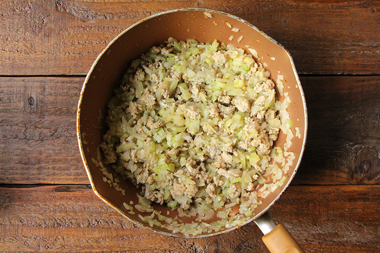 《ミートソースを作る①》 温めたフライパンにオリーブオイルをひき、鶏ももひき肉を入れ、中火前後で肉の色が変わるまで炒める。玉ねぎ、セロリを加え、さらに5分ほど炒める。