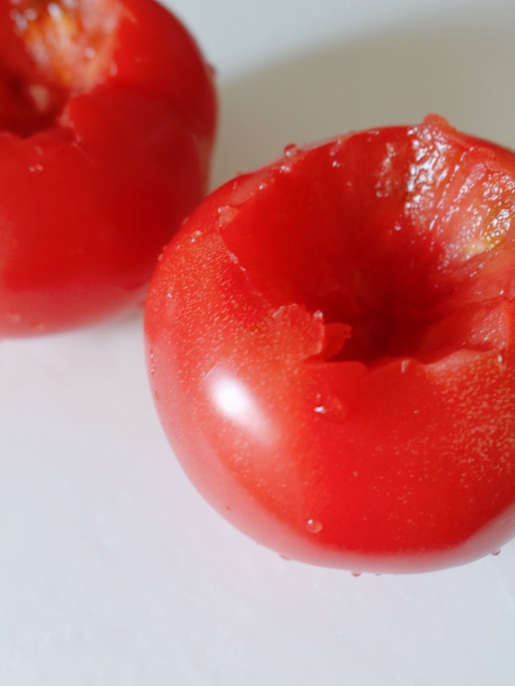 トマトはヘタをくり抜き、上下を切り落としてそれぞれ横に2等分する(切り落とした部分は使わない)。