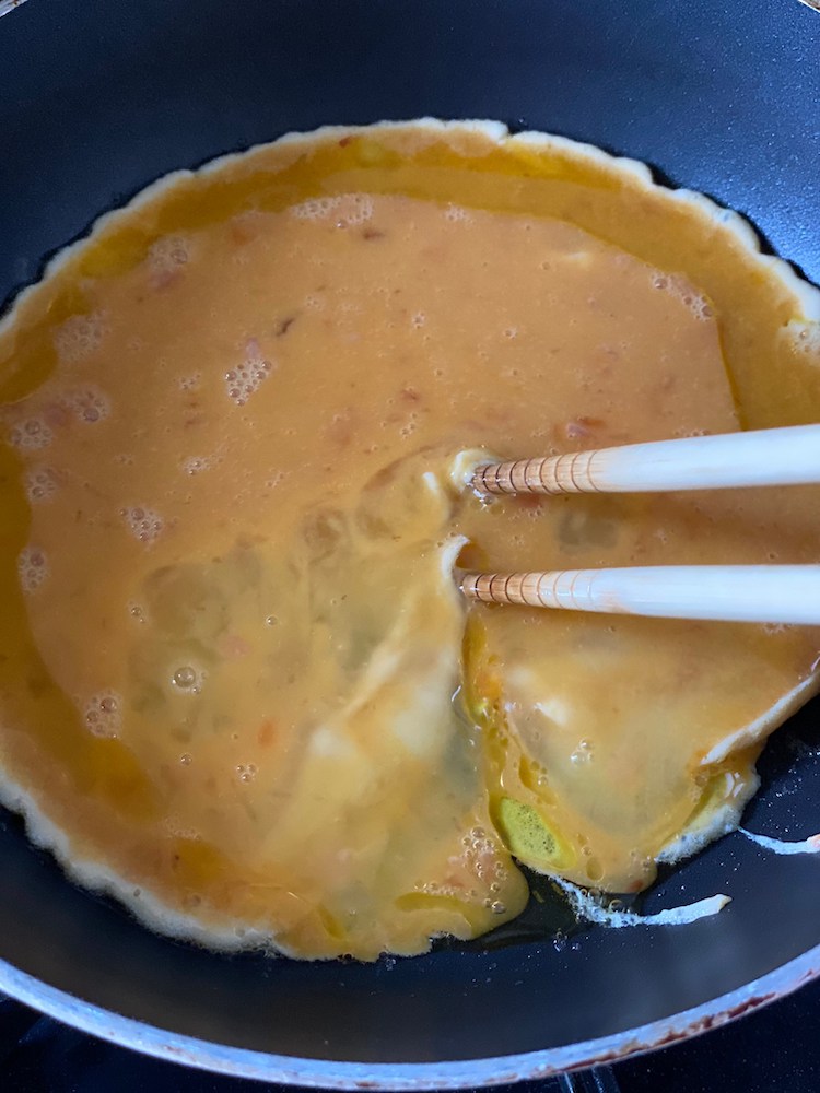 フライパンにサラダ油を入れて強火にかけ、フライパンが温まったら2の卵液を流し入れる。ふちの固まってきた部分から菜箸で中央へ寄せるようにして焼く。