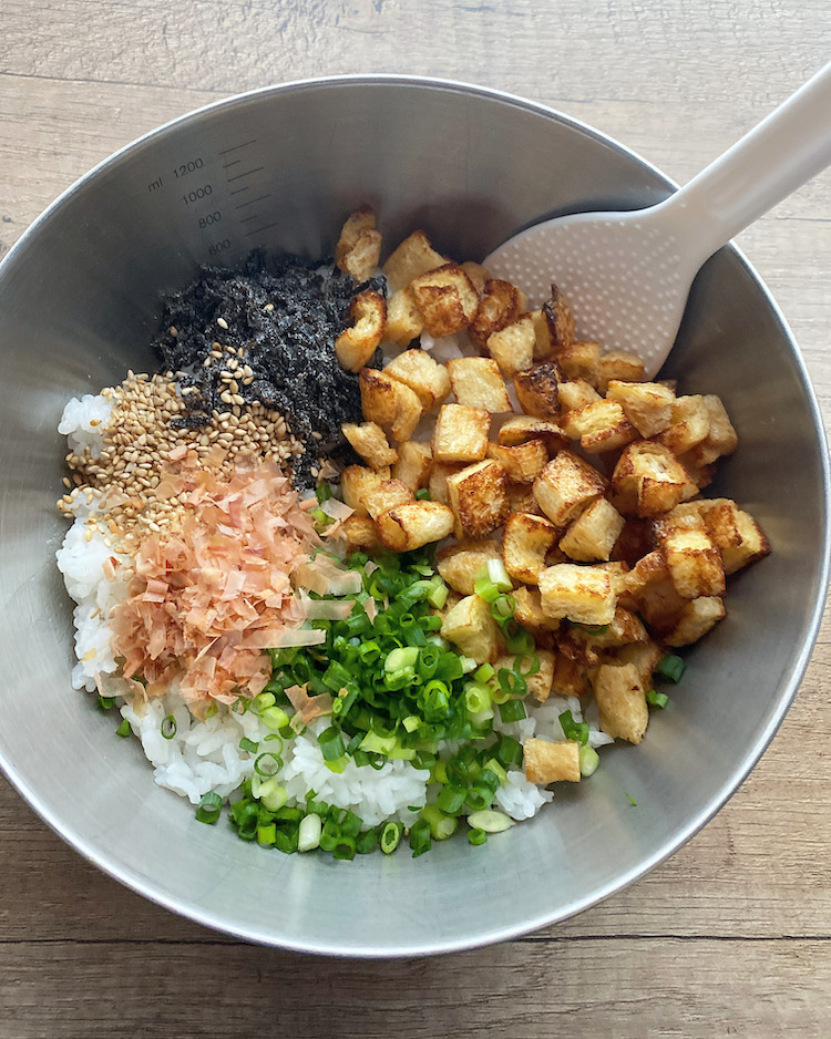 ボウルに温かいご飯、焼いた油揚げ、青ねぎ、かつお節、塩昆布、ごまを加え均一になるように混ぜる。