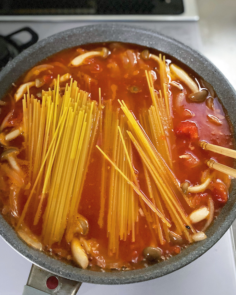 煮立ったらスパゲッティを半分に折って加え、スープに浸かるようにして蓋をする。時々混ぜながら、弱めの中火で袋の表記時間通り加熱する。